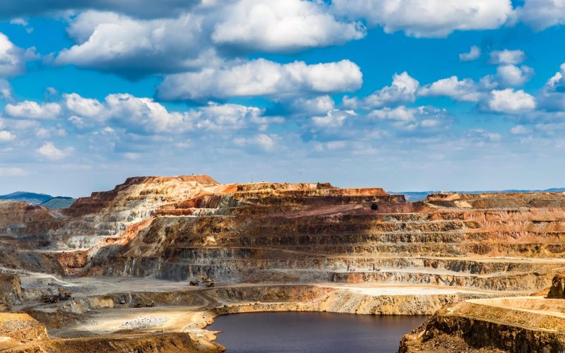 View on rocky stone landscape with water under bright sky in sunlight